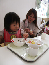 保育園での子供と保護者給食の写真