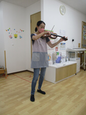 保育園先生がヴァイオリンを弾く写真