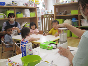 保育園で食育の時間を過ごす先生と子ども達の写真