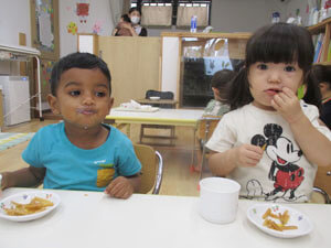 保育園の子どもがおやつの芋けんぴを食べる様子