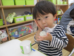 保育園で食事をする子供の写真
