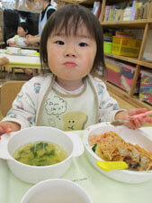保育園で給食を食べる子供の写真