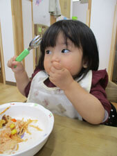 保育園で給食を食べる子供の写真
