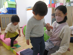 保育園で室内遊びをする子供達の写真