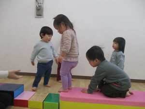 保育園で室内遊びをする子供達の写真