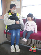 電車に乗る保育園児と先生の写真