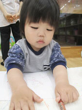 保育園でお絵描きをする子供の写真