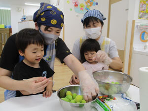 保育園で梅のヘタ取りをする園児の様子