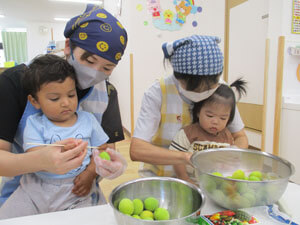 保育園で梅のヘタ取りをする園児の様子