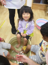 保育園の子供が足湯をする様子