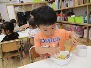 保育園で手作りきな粉を食べる園児