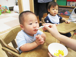 とうもろこしの料理を食べる保育園児