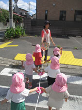 戸外散歩に向かう保育園児達と先生