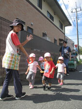 戸外散歩に向かう保育園児達と先生