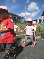 戸外散歩に向かう保育園児達と先生