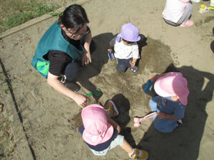 公園で遊ぶ保育園児と先生