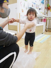 小麦粉を踏んでうどんを作る保育園児の様子