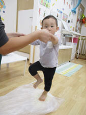 小麦粉を踏んでうどんを作る保育園児の様子