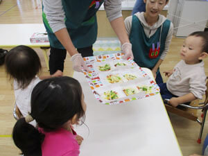 保育園児が先生が運んできた食べ物をみている様子