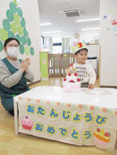 誕生日会で拍手をする先生と保育園児の様子
