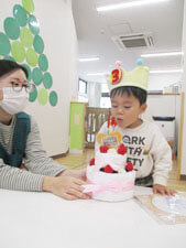 誕生日会でローソクの火を消す真似をする保育園児の様子