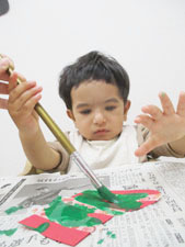 絵の具で描く保育園児