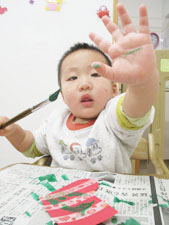 絵の具で描く保育園児