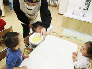 クレープを渡す保育園の先生