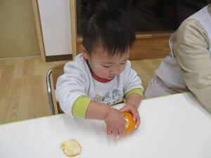 みかんを剥く保育園児の様子