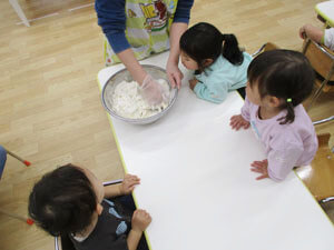 保育園児達に小麦粉を見せる先生