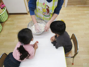 保育園児達に小麦粉を見せる先生