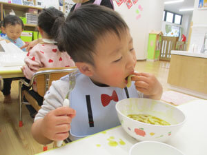 うどんを美味しそうに食べる保育園児