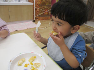 保育園でホットケーキを食べる園児
