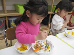 保育園でホットケーキを食べる園児