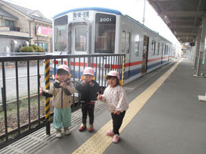 電車の前で写真を撮る園児