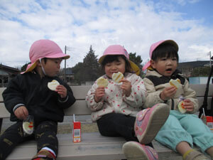 外で食事を食べる園児たち
