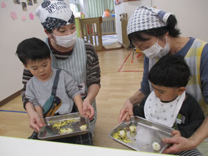 おにぎりを作る保育園児と先生