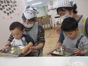 おにぎりを作る保育園児と先生
