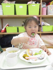 保育園の食育の時間にキャベツを美味しそうに食べる園児の様子