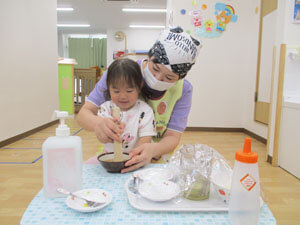 先生とごまをする保育園児