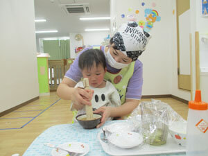 先生とごまをする保育園児