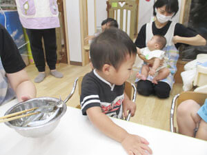 食育の時間にししゃもを観察する保育園児の様子