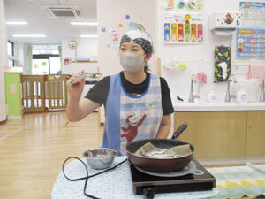 ししゃもを焼く保育園の先生