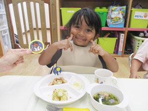 お月見給食を食べる笑顔の保育園児